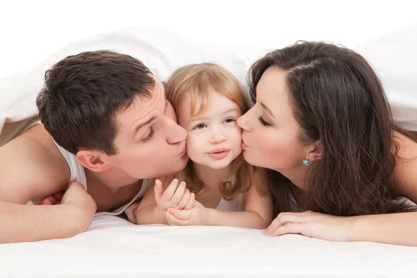 Famiglia felice, madre, padre e figlia sul letto bianco — Foto Stock