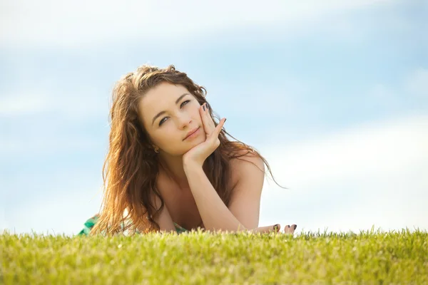 Yeşil çimenlerin üzerinde kalan genç kadın — Stok fotoğraf