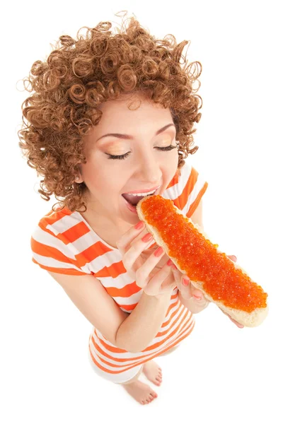 Fun woman eating the sandwich with red caviar on the white — Stock Photo, Image