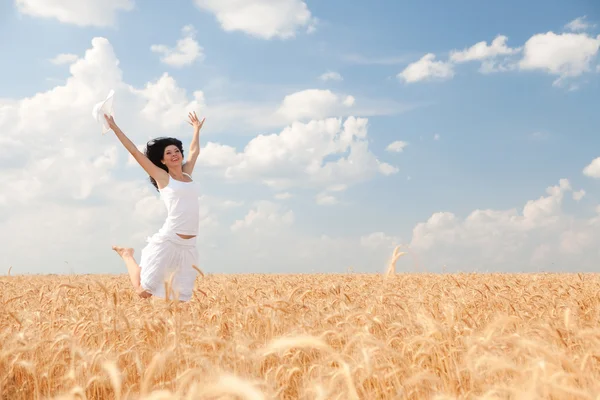 Happy woman jumping in golden wheat — Stock Photo, Image