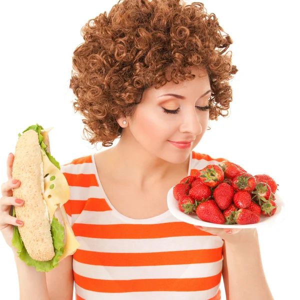 Веселая женщина с клубникой и сэндвичем на белом фоне — стоковое фото