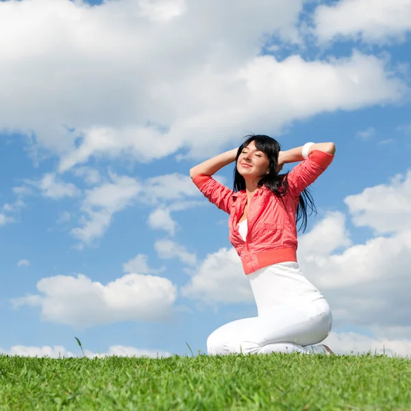 Glückliche junge Frau ruht auf dem grünen Gras — Stockfoto
