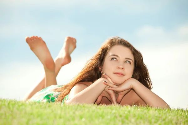 Mutlu genç kadın kalan yeşil çimenlerin üzerinde — Stok fotoğraf