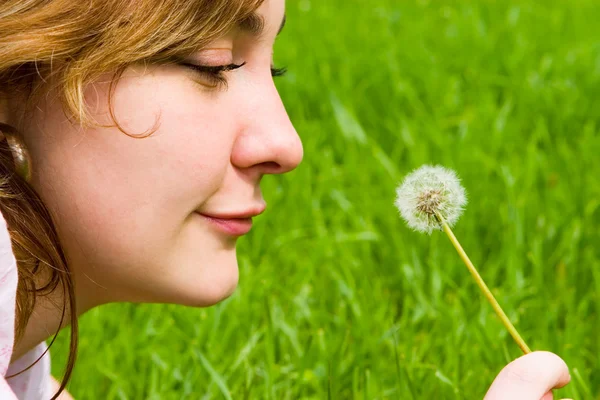 Happy girl blowing on the dandelion — Stock Photo, Image