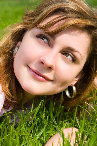 Süße Frau ruht sich auf dem grünen Gras aus — Stockfoto