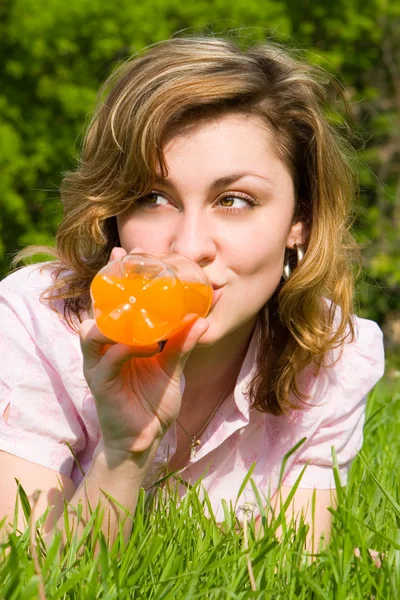 Mujer bonita bebiendo jugo en el glade de verano — Foto de Stock
