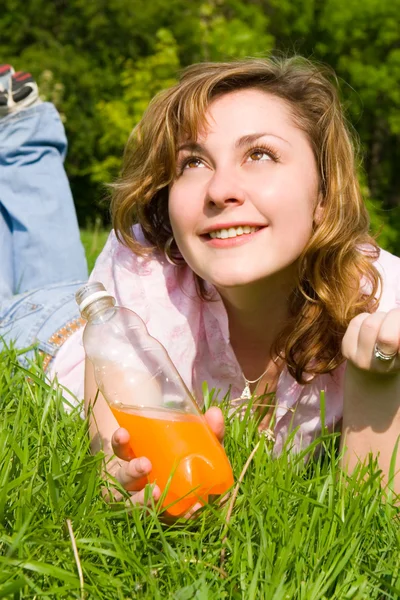 Mulher bonita beber suco na clareira de verão — Fotografia de Stock