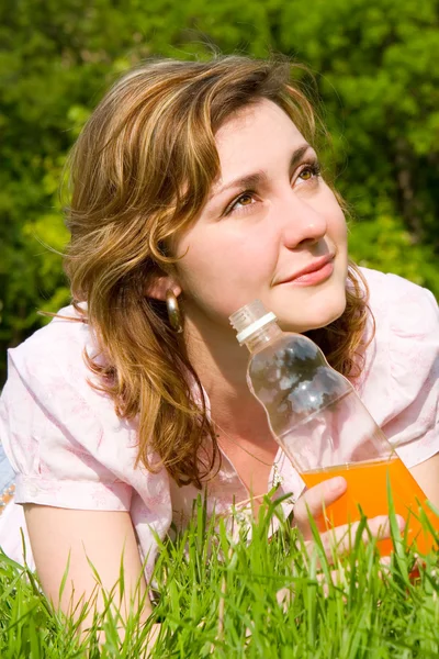 Hezká žena pití šťávy na letní glade — Stock fotografie