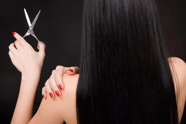Брюнетка с ножницами парикмахера — стоковое фото