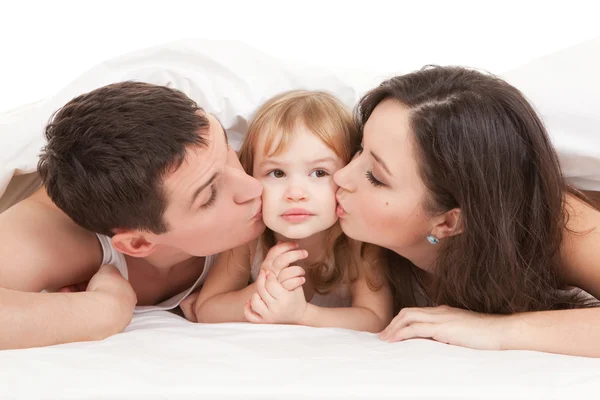 Mutlu aile, anne, baba ve kız beyaz yatakta — Stok fotoğraf