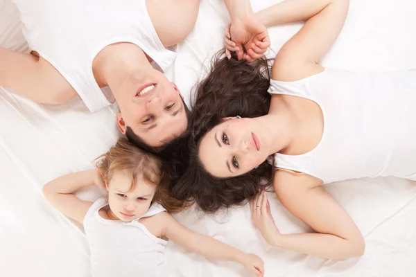 Lycklig familj, mor, far och dotter vilar på den vita b — Stockfoto