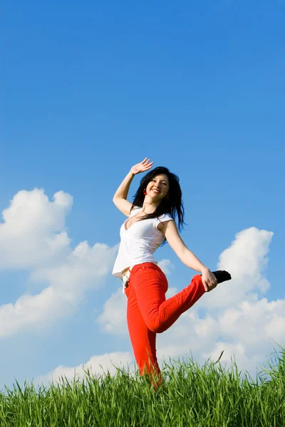Szczęśliwa młoda kobieta tańczy w zielonej trawie — Zdjęcie stockowe
