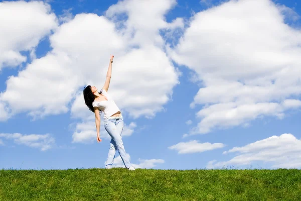 Красивая молодая женщина танцует на зеленой траве — стоковое фото
