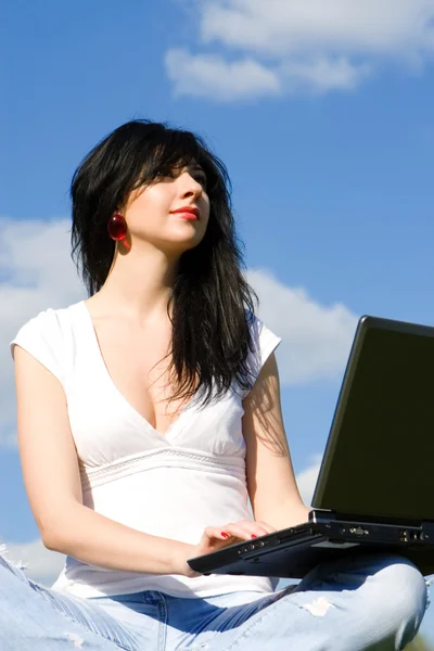 Bella donna con computer portatile su sfondo cielo — Foto Stock