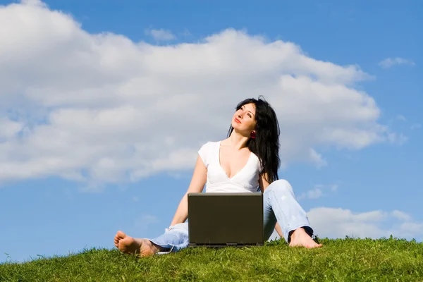 Krásná žena s laptopem na zelené trávě — Stock fotografie