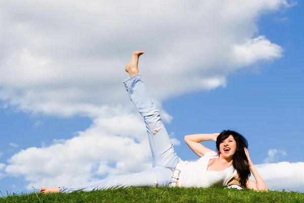 Красивая женщина отдыхает на зеленой траве — стоковое фото