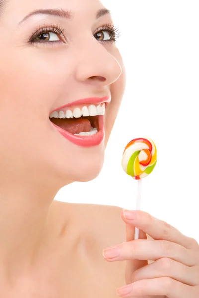 Bonita mulher lambendo doces no fundo branco — Fotografia de Stock