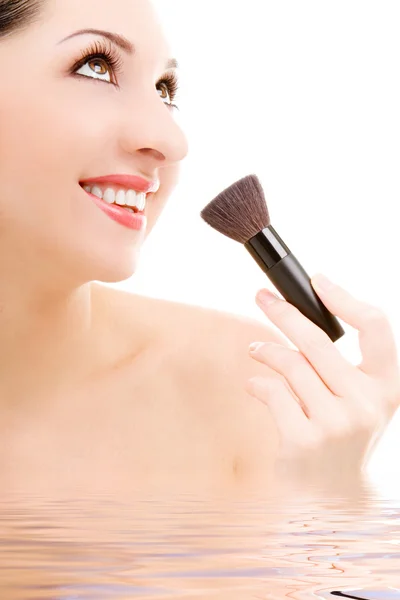 Pretty young woman with a make-up brush — Stock Photo, Image