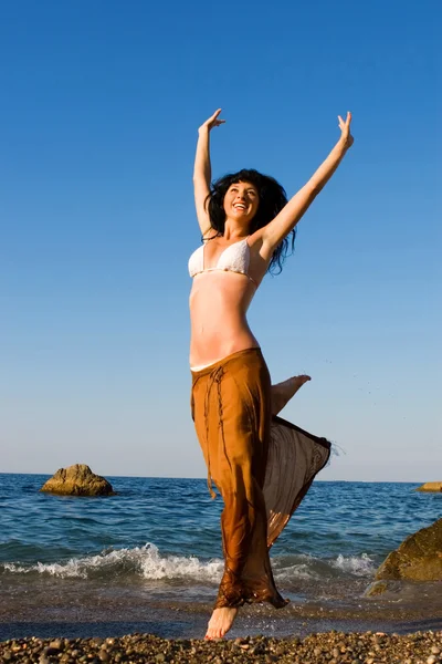 Szczęśliwa młoda kobieta taniec na plaży — Zdjęcie stockowe