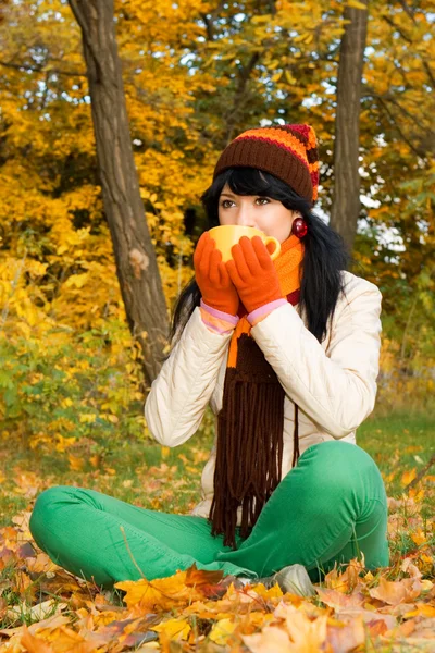 Çay bardağı sonbahar parkta genç güzel kadın — Stok fotoğraf