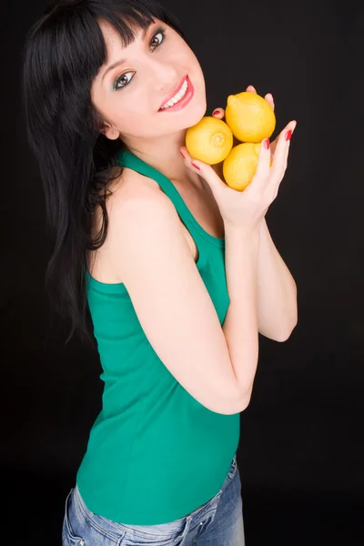 Ung kvinna med citroner — Stockfoto
