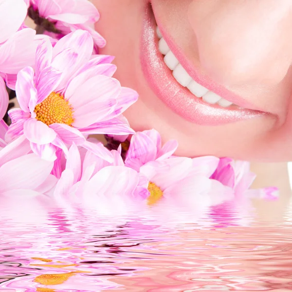 Χαμόγελο του νεαρή γυναίκα με λουλούδια — Φωτογραφία Αρχείου