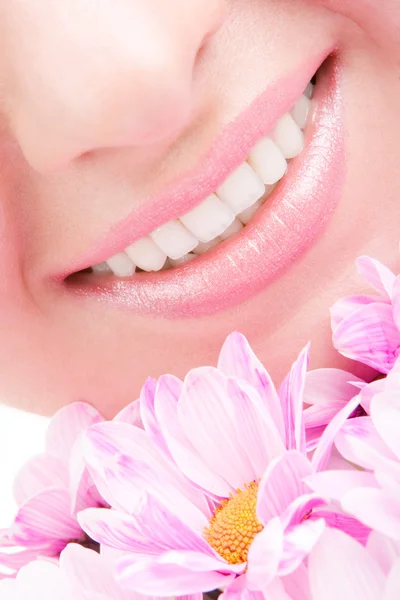 Glimlach van jonge vrouw met bloemen — Stockfoto