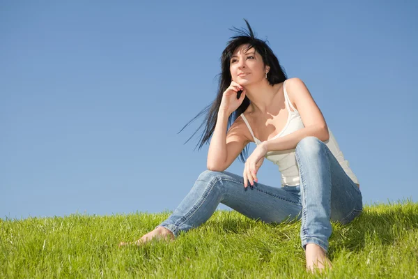 Gelukkig jonge vrouw rust op het groene gras — Stockfoto