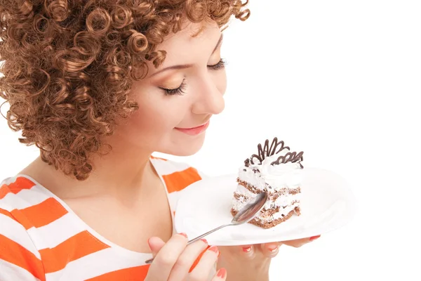Mulher divertida comer o bolo no fundo branco — Fotografia de Stock