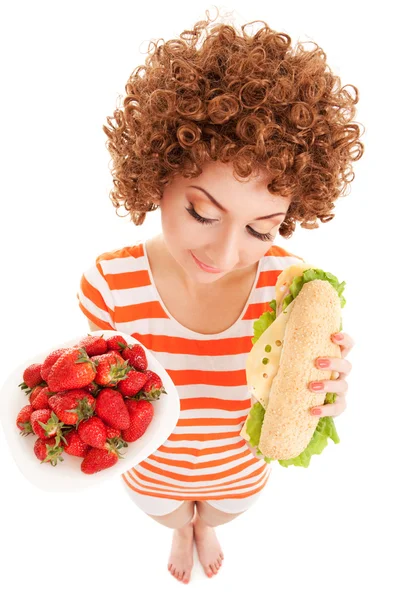 Mujer divertida con fresa y sándwich en el fondo blanco —  Fotos de Stock