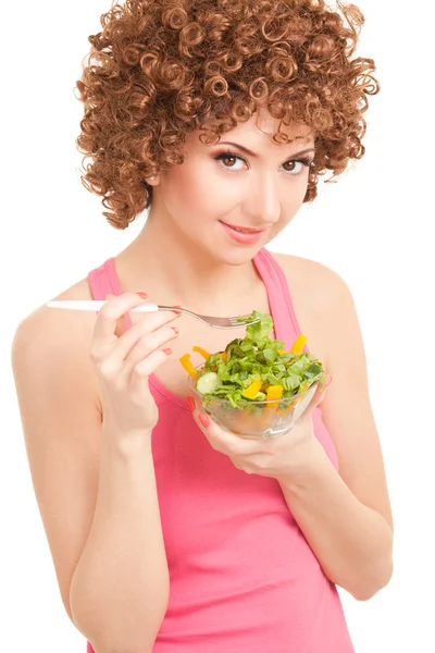 Веселая женщина ест салат на белом фоне — стоковое фото