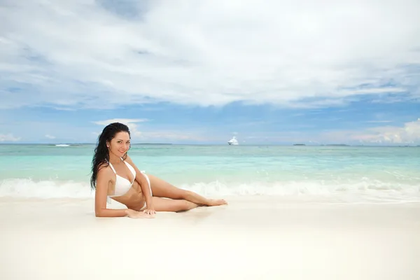 Gelukkig jonge vrouw rusten op het strand — Stockfoto