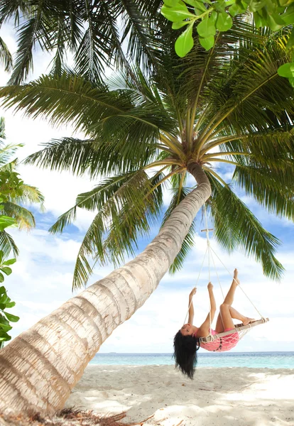 Mujer feliz relajándose en hamaca en una playa tropical — Foto de Stock