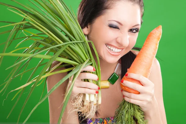 有胡萝卜和洋葱在绿色背景上的漂亮女孩 — 图库照片