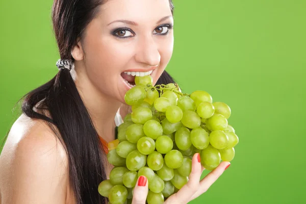Bella donna con uva sullo sfondo verde — Foto Stock