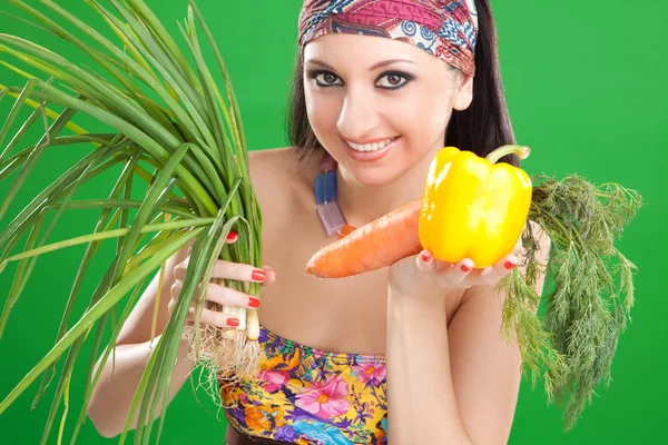 有蔬菜的绿色背景上的漂亮女孩 — 图库照片