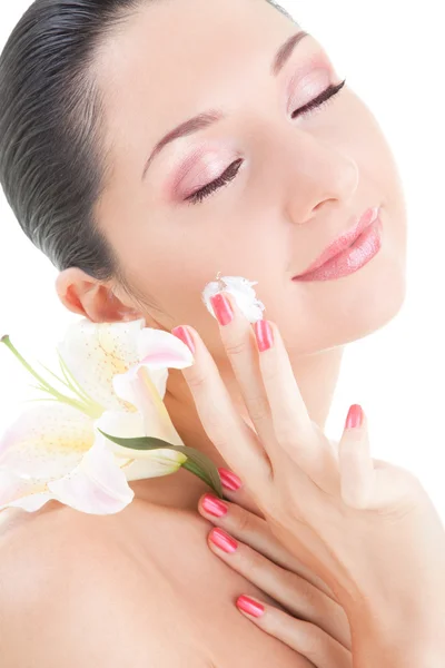 Woman with flower applying cream to her face on the white backgr — Stock Photo, Image