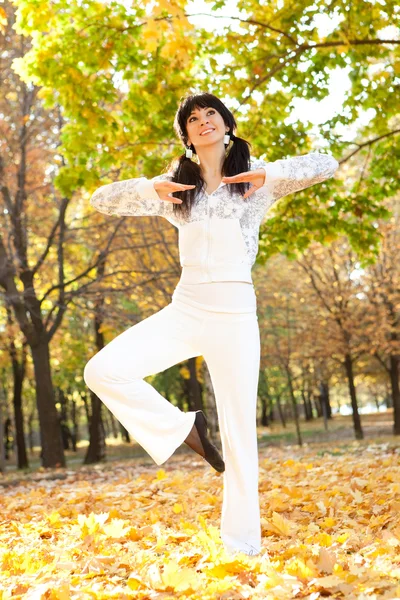 Mujer bonita haciendo ejercicios de yoga en el parque de otoño —  Fotos de Stock