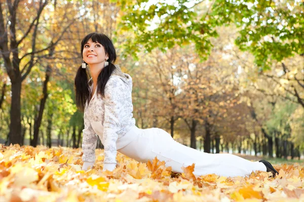 Mujer bonita haciendo ejercicios de yoga en el parque de otoño — Foto de Stock