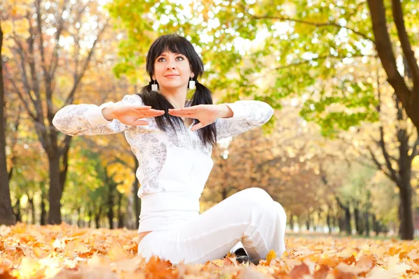 Güzel bir kadın yoga egzersizleri sonbahar Park yapıyor — Stok fotoğraf
