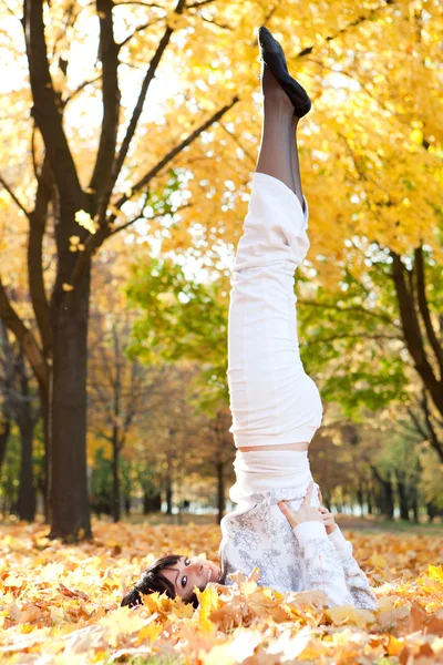 Όμορφη γυναίκα να κάνει ασκήσεις γιόγκα στο πάρκο φθινόπωρο — Φωτογραφία Αρχείου