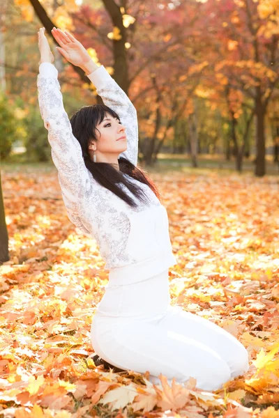 Mooie vrouw doen yoga oefeningen in de herfst park — Stockfoto