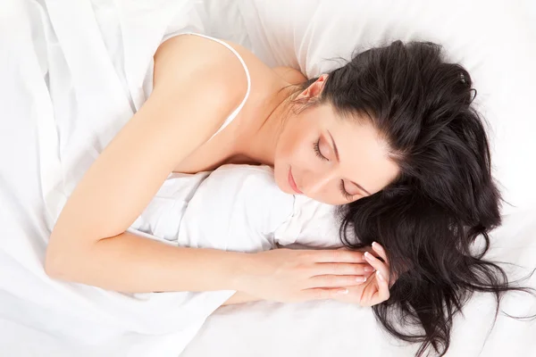 Sevimli kadın beyaz yatakta uyur — Stok fotoğraf