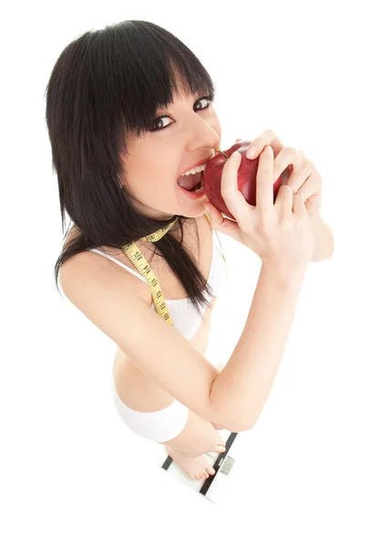 Mujer divertida con manzana roja y cinta métrica en las escamas de vidrio — Foto de Stock