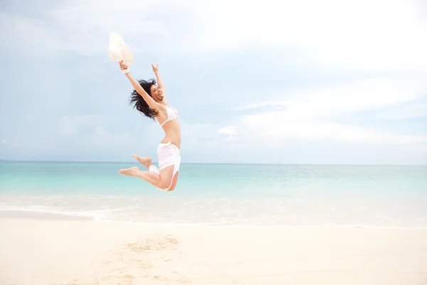 Šťastná mladá žena skákání v beach — Stock fotografie