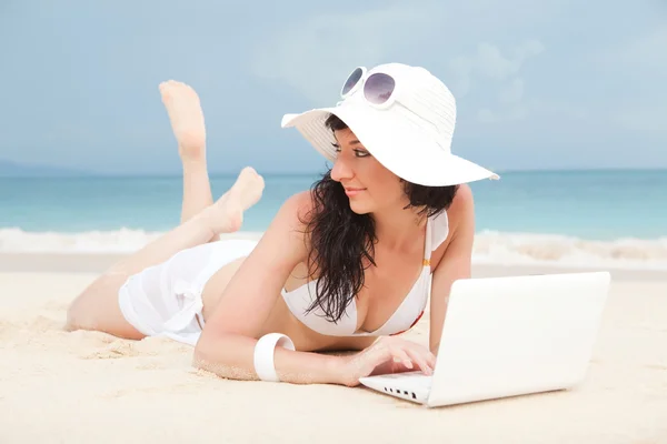 Roztomilá žena s bílým laptop na letní beach — Stock fotografie