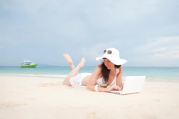 Leuke vrouw met witte laptop op het strand van de zomer — Stockfoto