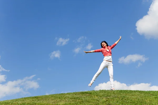 かなり若い女性の緑の草にジャンプ — ストック写真