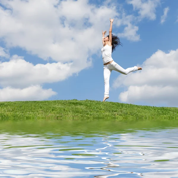Hübsche junge Frau springt auf grünem Gras — Stockfoto