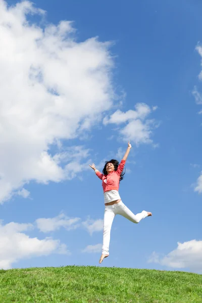 Mujer bastante joven saltando sobre hierba verde — Foto de Stock